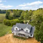 Panoramic view of covered porch highlighting farmhouse character and outdoor living space.
