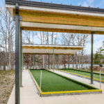 Close-up of the standing seam roof edge, gutter, and steel column connection on the bocce ball court shelter