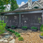 Screened-in porch addition with standing seam roof and closed privacy screens on a brick home in Fairfield Glade