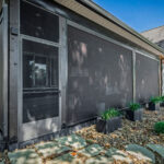 Close-up of the motorized privacy screens and entry door on the outdoor living space addition