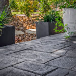 Stamped concrete patio edge with potted plants bordering the outdoor living space