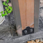 Close-up of the framing post base and anchor bolts on the stamped concrete floor