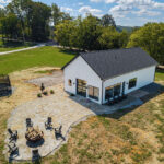 Aerial view of East Tennessee Contractors' custom 964 sq ft Clinch River guest home and event space, with floor-to-ceiling windows and a flagstone fire pit patio.